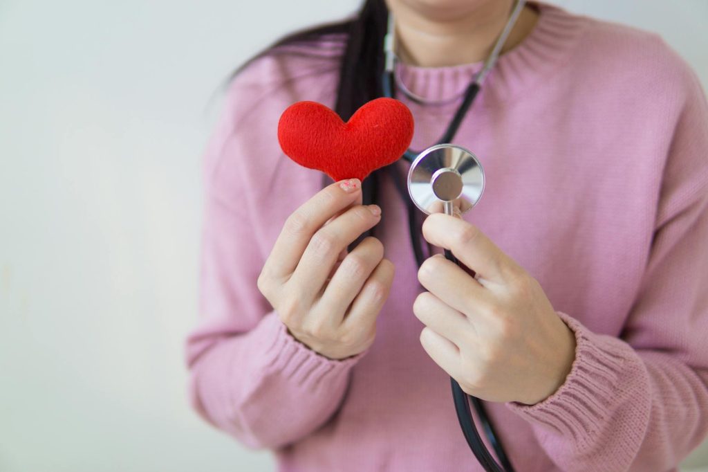 crop woman with stethoscope and heart