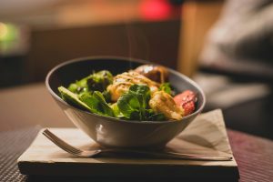 round stainless steel bowl with cooked meat and vegetables