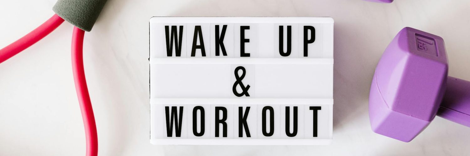 wake up and workout title on light box surface surrounded by colorful sport equipment