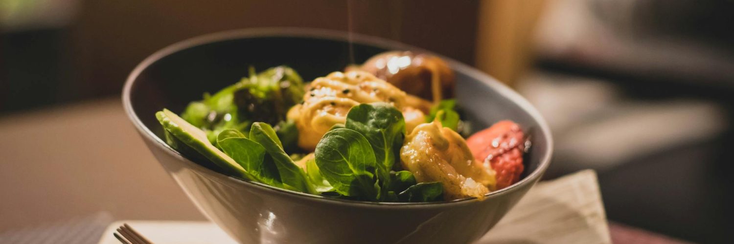 round stainless steel bowl with cooked meat and vegetables